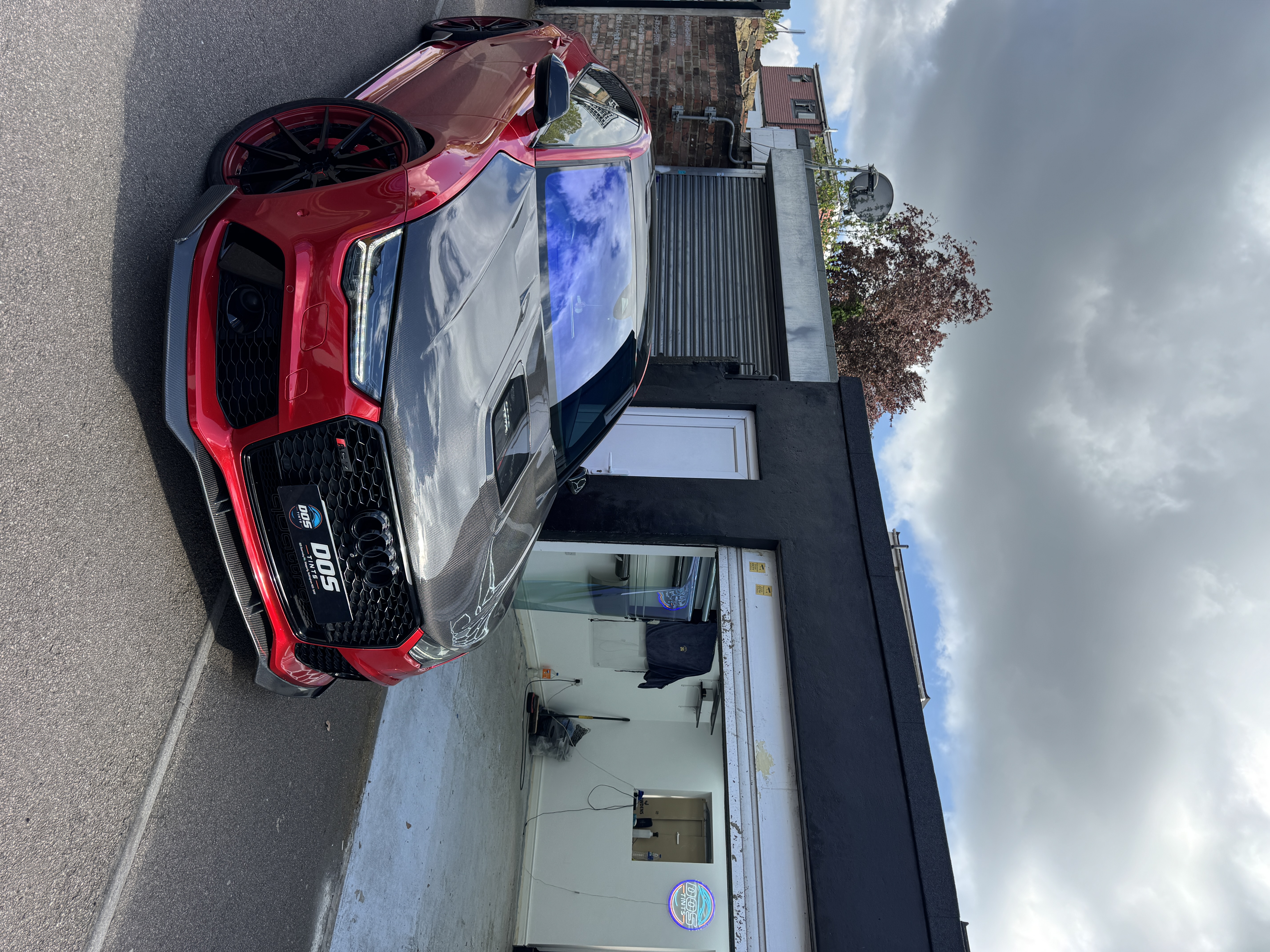 Audi RS7 with carbon bonnet and chameleon windscreen tint outside the DOS Tints shop
