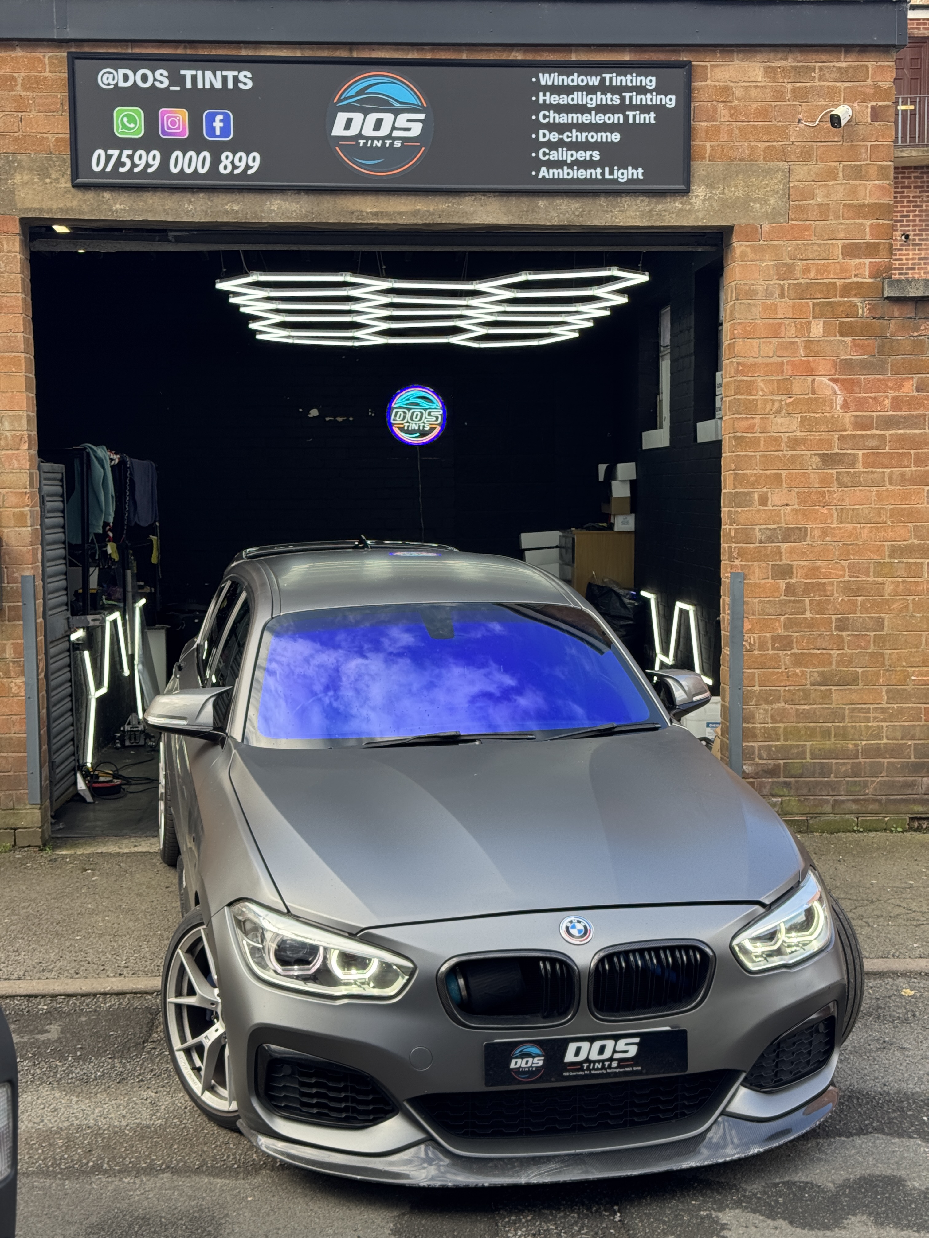 BMW M140i parked outside the DOS Tints shop after rear ceramic tint